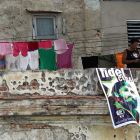 Una mujer en un balcón junto a un cartel con la imagen de Fidel Castro en La Habana. ALEJANDRO ERNESTO