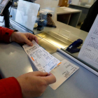 Una persona recoge unos billetes de tren. MARCIANO PÉREZ