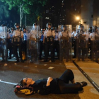 Una manifestante estirada en el suelo bloquea una de las calles de Hong Kong frente a una fila de policías.