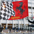 Dos aficionados de Ferrari colocan una bandera de la escuadería ante el hospital de Grenoble donde está ingresado Schumacher.