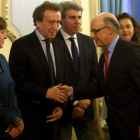 El ministro de Hacienda estrecha la mano de José Antonio de Santiago-Juárez en presencia de la vicepresidenta. RAQUEL P. VIECO