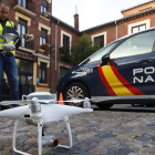 Los policías nacionales acompañan, ayer, al operador de drones para comprobar que todo está en regla. RAMIRO