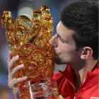 El tenista serbio besa el trofeo de ganador en Abu Dabi tras derrotar a Ferrer en la final.