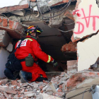 Un bombero peruano trata de escuchar si hay gente atrapada en el edificio. CHRISTIAN ESCOBAR MORA