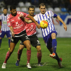 Ignasi Miquel intenta controlar el balón ante la acción de dos jugadores del CD Tenerife.