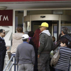 Varias personas hacen cola a las puertas de una sucursal del Banco Laiki en Nicosia.