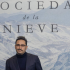 El director de ‘La sociedad de la nieve’, Juan Antonio Bayona, ante el cartel de la película. JAVIER LIZÓN