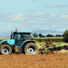 Un agricultor realiza labores con su tractor en una finca de cultivo.