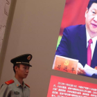 Un agente de policía permanece junto a una foto del presidente Xi Jinping, exhibida en una exposición sobre los logros de China en los últimos cinco años, en Pekín.