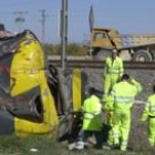 Unos operarios retirar los restos del camión que chocó contra el tren de Zaragoza