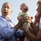 Bush sostiene a un bebé a su llegada a Trinwillershagen para una comida al aire libre