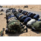 Los rebeldes libios rezan antes de combatir contra las fuerzas del gobierno de Gadafi, ayer.