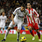 Karim Benzemá protege el balón ante el atlético Arda Turan.