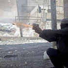 Un palestino lanza un petardo a las fuerzas de seguridad israelís.