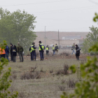 Bomberos y policías recorren el descampado donde se estrelló el avión.