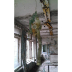 Una de las aulas de la escuela de Pripiat con una máscara de gas colgando del techo.
