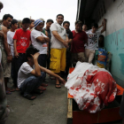 Un grupo de familiares permanece junto al cuerpo de un supuesto drogadicto asesinado durante una operación policial contra las drogas ilegales al interior de una mezquita en Manila.