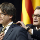 Mas impone la medalla representativa del cargo al nuevo presidente, Puigdemont.