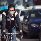 un ciclista con una mascarilla circulando hoy por las calles de Madrid