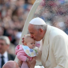Francisco besa a un bebé durante una audiencia en la plaza de San Pedro del Vaticano.