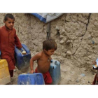 Unos niños cargan bidones de agua en las afueras de Kabul.