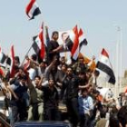 Ciudadanos sirios muestran banderas nacionales para celebrar el retorno de sus tropas