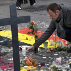 Un hombre deja flores en el tributo a las víctimas de los atentados de Bruselas