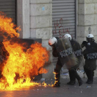 Antidisturbios, envueltos por las llamas de una bomba incendiaria durante las protestas.