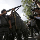 Un policía antidisturbios apunta con su arma a un grupo de manifestantes, durante la protesta en Sao Paulo de este jueves.