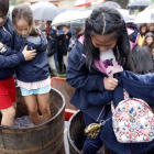 LOs niños disfrutaron bajo la lluvia de la experiencia de pisar la uva y catar el primer mosto de la temporada. MARCIANO PÉREZ