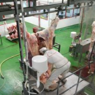 Dos operarios del ya cerrado matadero de Ponferrada despiezan la carne de dos reses