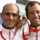 Los regatistas españoles Iker Martínez (d) y Xabier Fernández muestran la medalla de plata