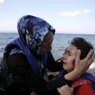 Una mujer afgana tranquiliza a su hija, que llora de miedo después de la travesía por mar entre Turquía y Grecia.