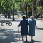 Dos ancianas caminan por una ciudad.