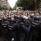 Agentes antidisturbios de la Policía Nacional forman un cordón de seguridad en los alrededores del colegio Ramón Llull de Barcelona.