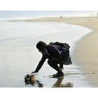 Mai Otomo, estudiante de 17 años, deja un ramo de flores en el mar en recuerdo de su padre y dos compañeros fallecidos.