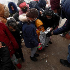 Imagen de una fundación repartiendo juguetes bajo la nieve a los niños de la Cañada Real. MARISCAL