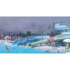 Usuarios de la piscina de Toboganes de Trobajo contemplan el incendio mientras otros siguen bañándose