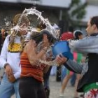 Un joven lanza un caldero de agua a una chica ayer durante la celebración de la fiesta del agua