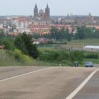 Un vehículo circula por la carretera Astorga-Nogarejas con la capital maragata al fondo de la imagen