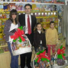 El propietario de la tienda, junto a los galardonados.