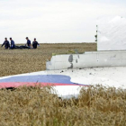 Varias personas transportan un cadáver en una camilla en medio de los destrozos de un Boeing 777, vuelo MH17 de Malaysia Airlines, derribado cerca de Donetsk (Ucrania).