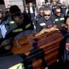 Compañeros de profesión sujetan el féretro con los restos mortales del bombero fallecido