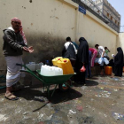 Yemenís llenan de agua potable botellas de plástico en una fuente de Saná.