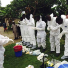 Voluntarios preparándose para ponerse los monos de aislamiento para tratar con enfermos de ébola, en Sierra Leona.
