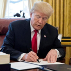 Trump firma la ley sobre la reforma fiscal, en el Despacho Oval de la Casa Blanca, en Washington, el 22 de diciembre.