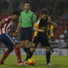 Álvaro Antón disputa el balón con un rival ante la atenta mirada del colegiado asturiano Areces Franco.