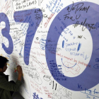 Fotografía de archivo del 13 de marzo del 2014 de un hombre escribiendo mensajes en recuerdo a las víctimas del vuelo MH370 de Malaysia Airlines en el aeropuerto internacional de Kuala Lumpur (Malasia).