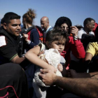 Una niña siria es ayudada a bajar de su embarcación en la isla griega de Lesbos, este sábado.