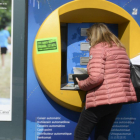 Una mujer saca dinero del cajero automático.